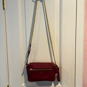 Coach Flight Bag in deep wine with gold colored adjustable shoulder strap.